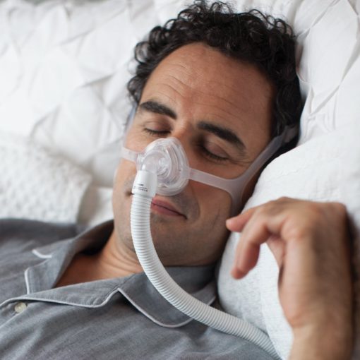 A man using the Philips Respironics Wisp Nasal Mask