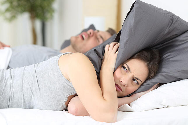 girl having issues to sleep because his boyfriend is snoring