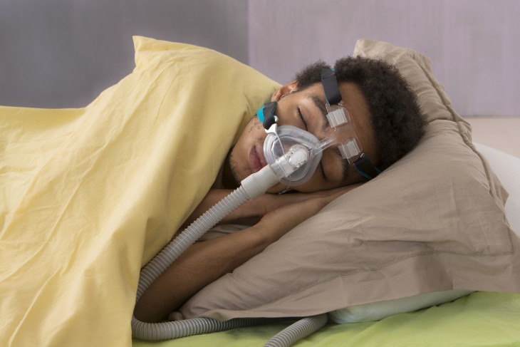 a boy sleeping with a cpap machine