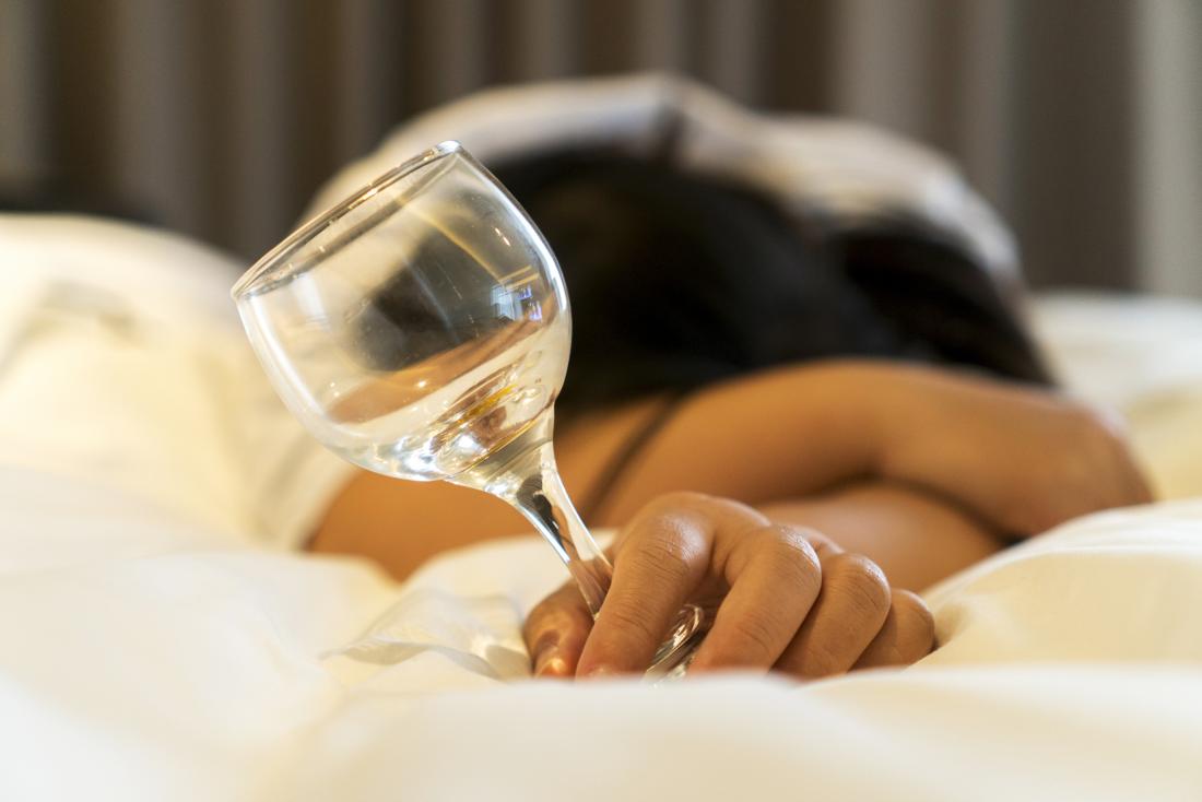 a woman on the bed holding a glass of wine