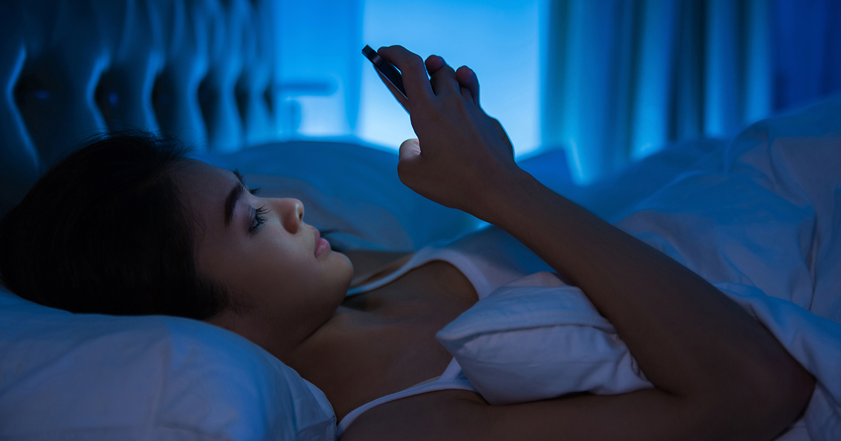 woman using the cellphone on the bed